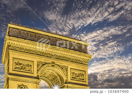 Arc de Triomphe (against the background of sky with clouds), Paris, France. The walls of the arch are engraved with the names of 128 battles and names of 660 French military leaders (in French) 103697400