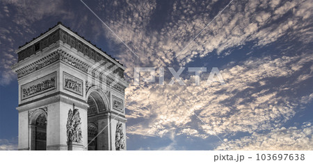 Arc de Triomphe (against the background of sky with clouds), Paris, France. The walls of the arch are engraved with the names of 128 battles and names of 660 French military leaders (in French) 103697638