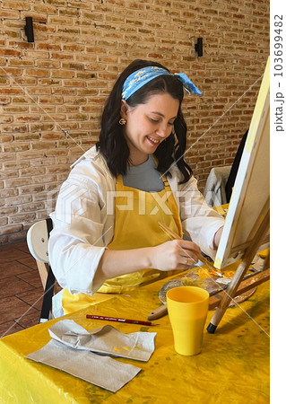 Woman with brush painting on canvas Woman with brush painting on canvas 103699482