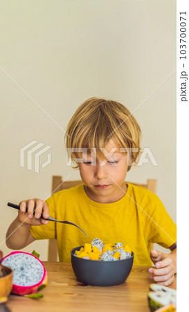 Boy eats fruit. Healthy food for children. Child eating healthy snack. Vegetarian nutrition for kids. Vitamins for children VERTICAL FORMAT for Instagram mobile story or stories size. Mobile wallpaper 103700071