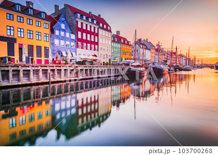 Copenhagen, Denmark. Nyhavn, Kobenhavn's iconic canal, colorful sunrise water reflection. 103700268