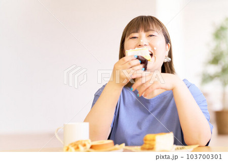 豪快にケーキを食べる若い女性 豪快にケーキを食べる若い女性 103700301