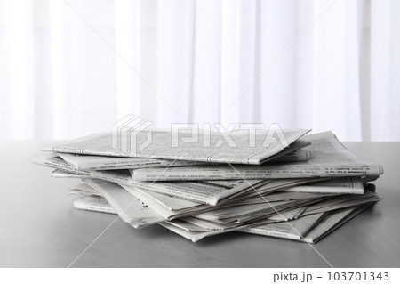 Pile of newspapers on grey table. Journalist's work 103701343