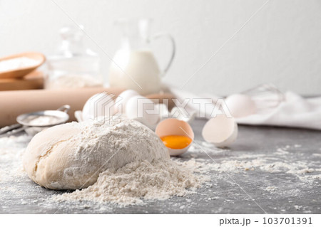 Wheat dough and products on grey table, space for text. Cooking pastries 103701391