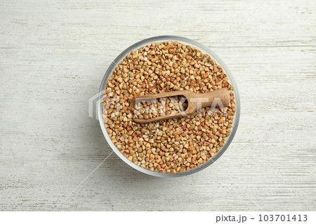 Uncooked green buckwheat grains in bowl on white wooden table, top view Uncooked green buckwheat grains in bowl on white wooden table, top view 103701413