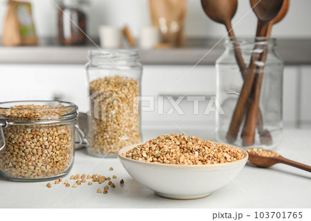 Uncooked green buckwheat grains on white table Uncooked green buckwheat grains on white table 103701765