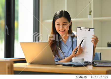 Smiling female doctor having online consultation with patient on laptop in clinic. Tele medical, healthcare and technology 103703295