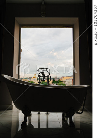 bathtub in front of a large window. retro-style bathroom  103704367