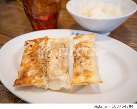 【日本】白いお皿に乗せられれた焦げ目のついた3本の棒餃子と白米 【日本】白いお皿に乗せられれた焦げ目のついた3本の棒餃子と白米 103704594