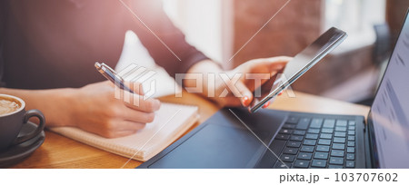 Woman sitting in cafe at the table and working on the laptop. Woman sitting in cafe at the table and working on the laptop. 103707602