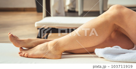 Womans feet in white bathrobe lying on sofa and relaxing at the roof. Womans feet in white bathrobe lying on sofa and relaxing at the roof. 103711919