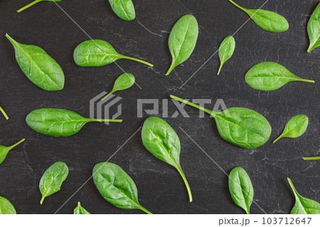 Corn salad ( Valerianella locusta ) leaves arranged in pattern over black slate like board - overhead shot. Healthy green leaf food concept. Corn salad ( Valerianella locusta ) leaves arranged in pattern over black slate like board - overhead shot. Healthy green leaf food concept. 103712647