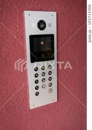Modern intercom with video camera, apartment code on the panel of the electronic intercom. The concept of protection and security of the apartment. Modern intercom with video camera, apartment code on the panel of the electronic intercom. The concept of protection and security of the apartment. 103714366