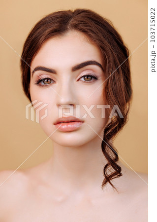 Portrait of beautiful woman looking at camera isolated on beige background. 103715022