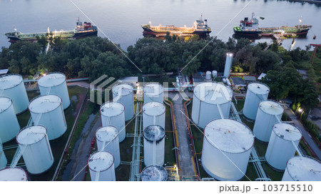 Aerial view oil storage tanks and tanker in river at night, Aerial view of oil storage tanks and tanker ship in the port town, Tanker ship in the port. 103715510