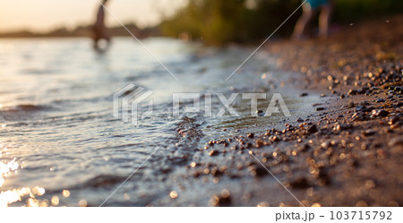 Close-up of the shore of a lake or river made of small stones against 103715792
