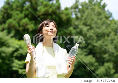 屋外で扇風機を使う女性 103717250