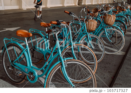 colorful blue bicycles in the parking lot, bike rental. 103717327