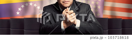 Politician or businessman on oil barrels background and background of Venezuela and America flags 103718618