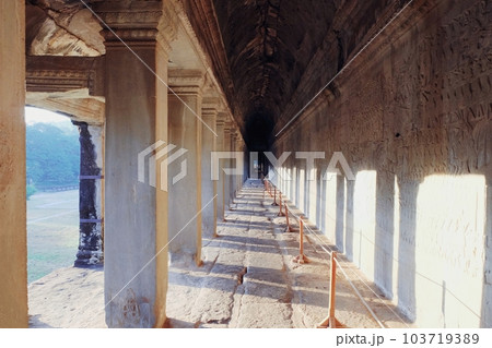 The ancient Angkor temple in Cambodia features a long corridor with columns. The ancient Angkor temple in Cambodia features a long corridor with columns. 103719389