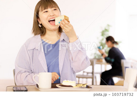 美味しそうな表情でケーキを食べる若い女性 103719732
