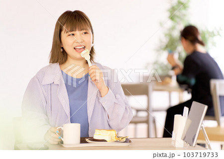 カフェでケーキを食べる若い女性 カフェでケーキを食べる若い女性 103719733