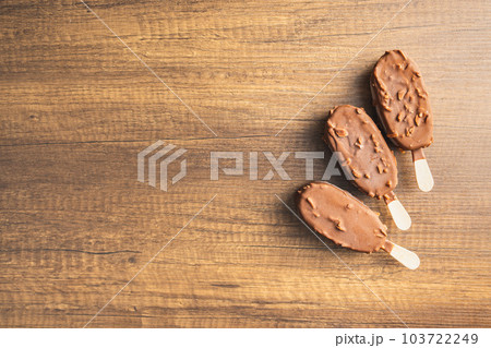 Popsicle, ice cream covered with chocolate on wooden table. Top view. 103722249