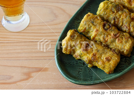 グリーンの皿にもったカレー風味の竹輪の磯辺揚げ グリーンの皿にもったカレー風味の竹輪の磯辺揚げ 103722884