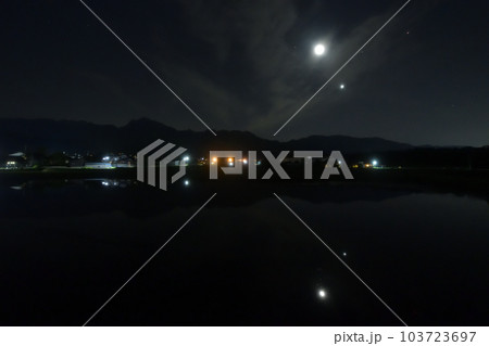 北杜市白州町、薄い雲のベールかかる宵の空に寄添う月と金星を映す水田 103723697