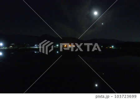 北杜市白州町、薄い雲のベールかかる宵の空に寄添う月と金星を映す水田 103723699