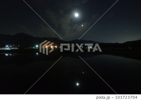 北杜市白州町、薄い雲のベールかかる宵の空に寄添う月と金星を映す水田 103723704