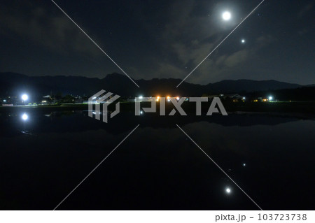 北杜市白州町、薄い雲のベールかかる宵の空に寄添う月と金星を映す水田 103723738