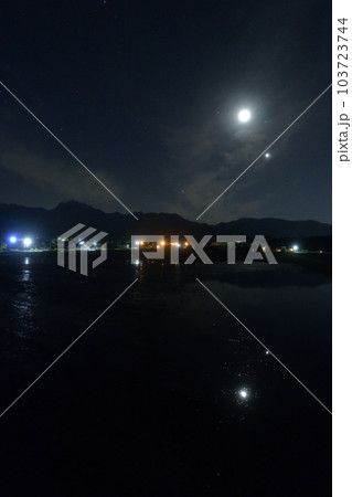 北杜市白州町、薄い雲のベールかかる宵の空に寄添う月と金星を映す水田 103723744