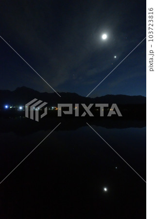 北杜市白州町、薄い雲のベールかかる宵の空に寄添う月と金星を映す水田 103723816