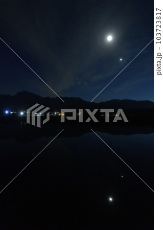 北杜市白州町、薄い雲のベールかかる宵の空に寄添う月と金星を映す水田 103723817