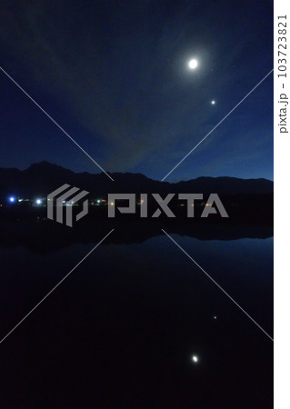 北杜市白州町、薄い雲のベールかかる宵の空に寄添う月と金星を映す水田 103723821