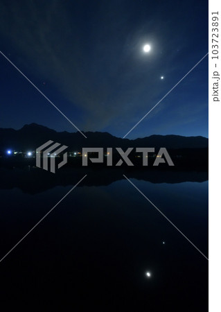 北杜市白州町、薄い雲のベールかかる宵の空に寄添う月と金星を映す水田 103723891