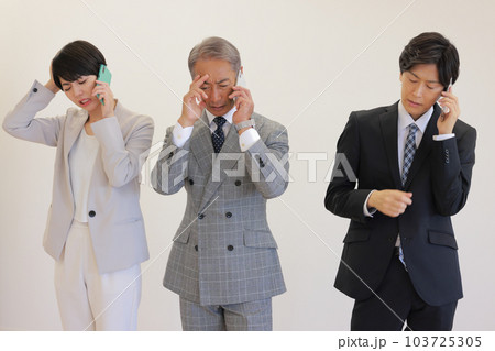 困ってしまう電話を受ける3人のビジネスパーソン_5 103725305