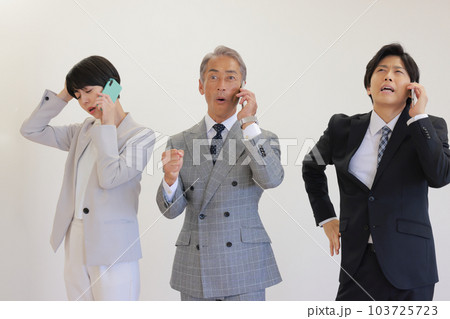 喜んだり嘆いたり三者三様の電話する3人のビジネスパーソン_1 喜んだり嘆いたり三者三様の電話する3人のビジネスパーソン_1 103725723
