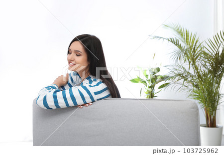 Young woman relaxing on couch at home Young woman relaxing on couch at home 103725962