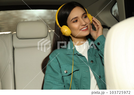 Young woman listening to audiobook in car 103725972