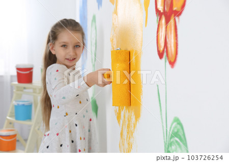 Little child painting wall with roller brush indoors 103726254