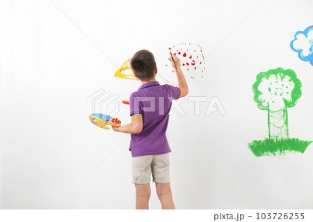 Little child painting on white wall indoors 103726255