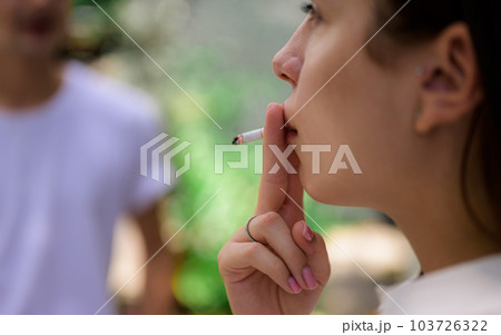 Young couple of man and woman smoking cigarette together 103726322