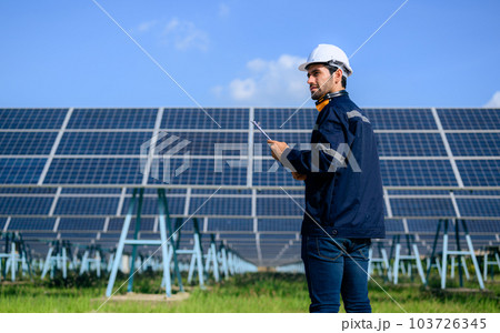 Engineer worker portrait with solar panel at solar farm 103726345