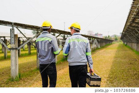 Maintenance engineer checking solar panels on solar cell farm Maintenance engineer checking solar panels on solar cell farm 103726886