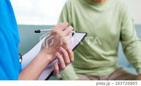 Caregiver nurse taking care of elderly grandfather sitting on sofa at home 103726905