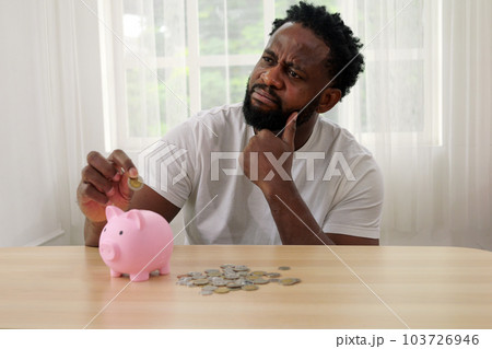 Man putting coin of cash into ceramic piggy bank Man putting coin of cash into ceramic piggy bank 103726946