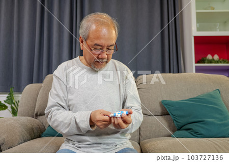 Caregiver nurse taking care of elderly grandfather sitting on sofa at home Caregiver nurse taking care of elderly grandfather sitting on sofa at home 103727136