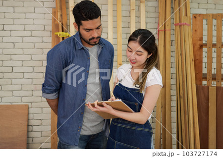 Couple of carpenters making furniture in wood workshop Couple of carpenters making furniture in wood workshop 103727174